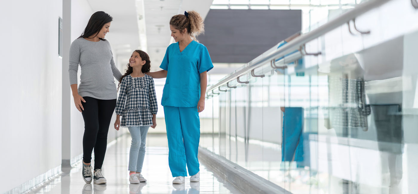 A mother, child, and doctor visting in a hospital